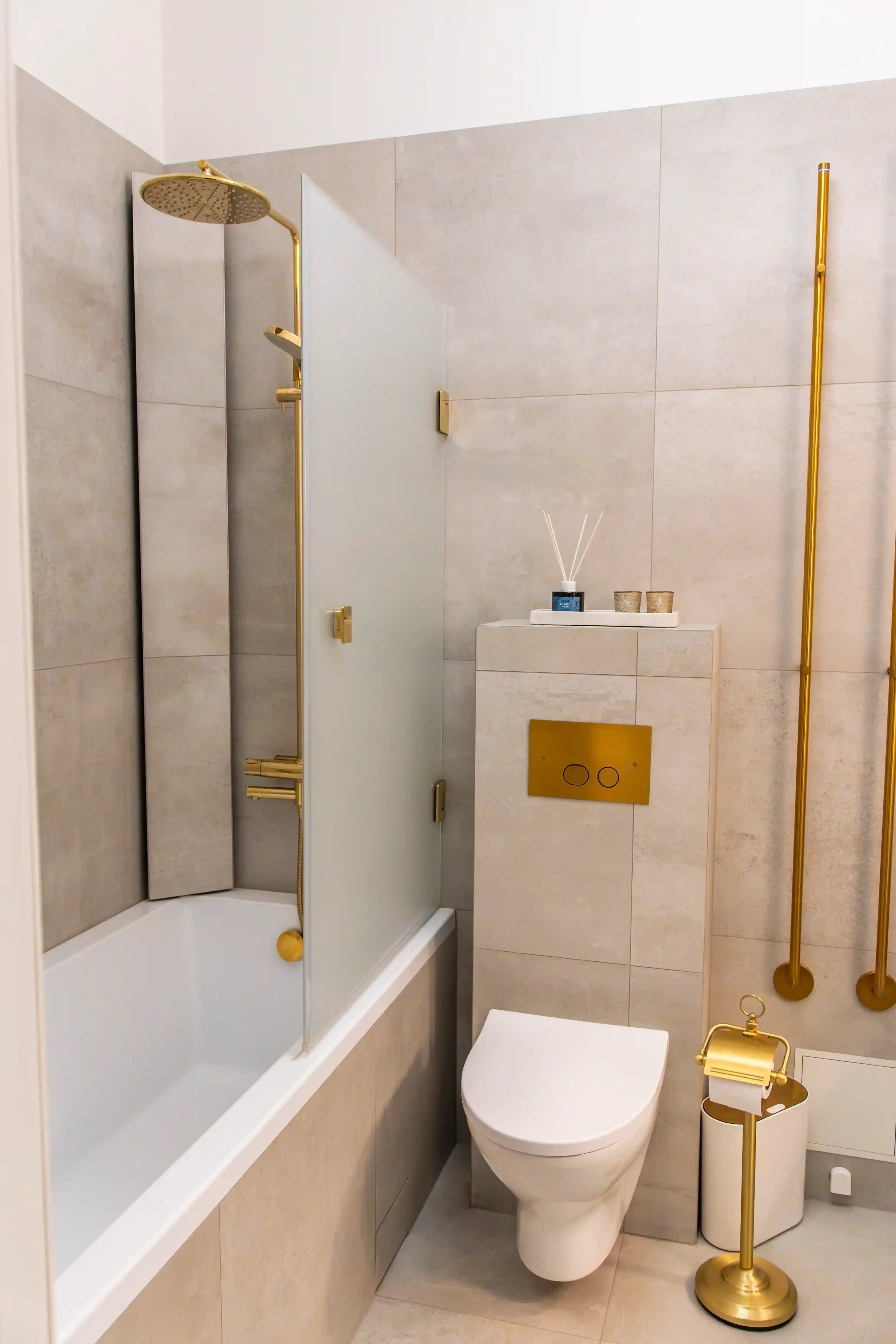 Badrumsrenovering i Stockholm med sekelskiftesstil, badkar, beige kakel och mässingsdetaljer